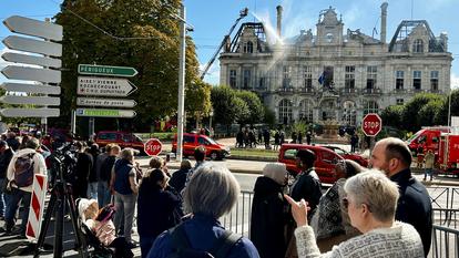 Des personnes devant l’Hôtel de Ville de Limoges, brûlé et détruit, qui a été incendié et largement détruit samedi 17 octobre lors d’une attaque criminelle au milieu de manifestations contre le coût de la vie et la hausse des prix des carburants.