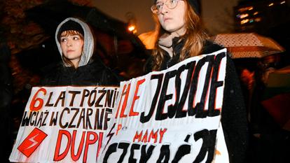Deux jeunes femmes manifestent avec des pancartes « Combien de temps encore devrons-nous attendre ? » (à gauche) dans une manifestation nationale « Pro Choice » appelant le gouvernement à tenir ses promesses de dépénaliser l’avortement en Pologne, le 22 octobre 2026.