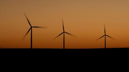 Des éoliennes au crépuscule sur des terres agricoles.