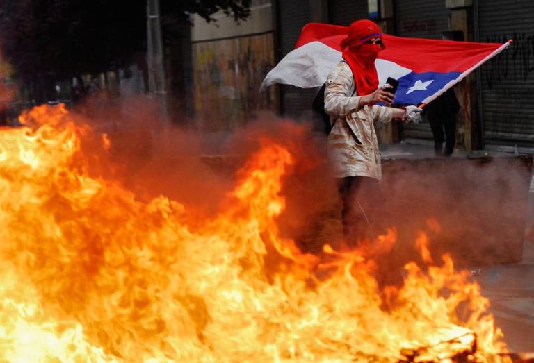 Un protestataire tient un drapeau chilien, le 25 octobre à Concepcion.
