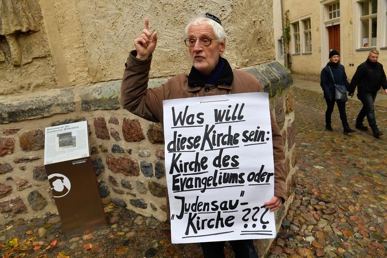 «Que veut être cette Église ?» affiche la pancarte de ce manifestant contre la sculpture «Judensau»