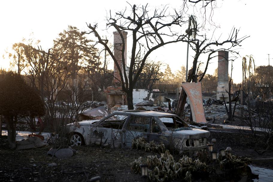 La carcasse d’une voiture et des maisons brûlées par l’incendie, dans le quartier de Pacific Palisades. David Ryder / REUTERS