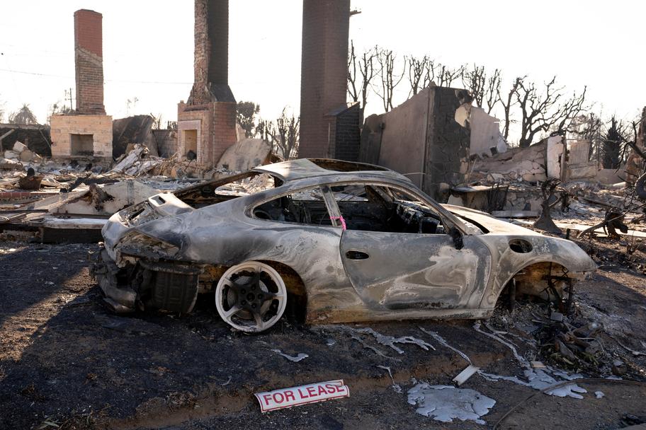 Un panneau de location est posé au sol à côté d’une voiture brûlée, dans le quartier de Pacific Palisades. David Ryder / REUTERS