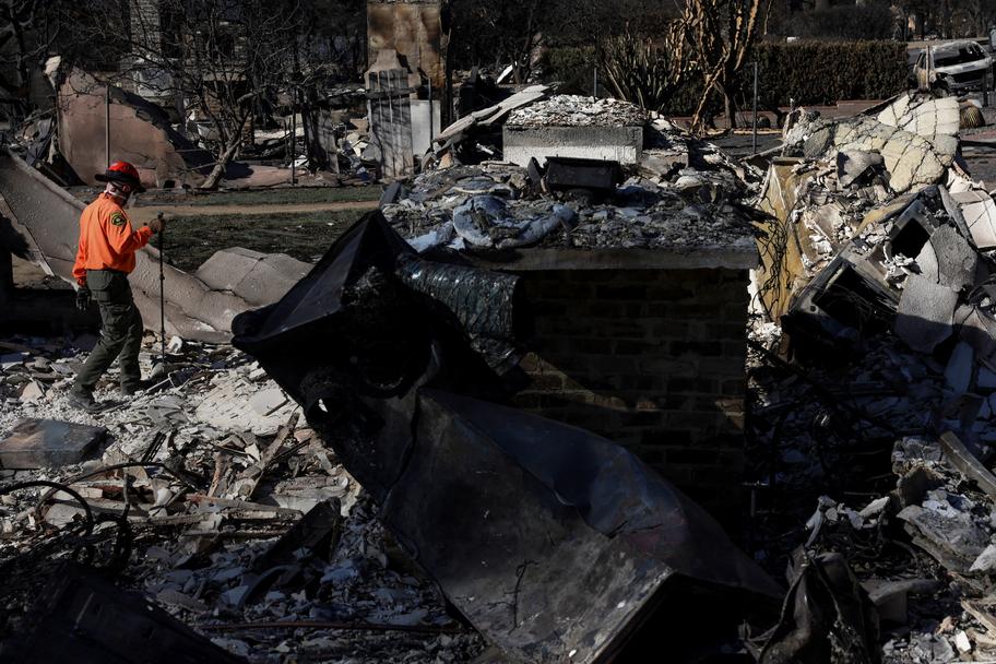 Un membre de l’équipe de recherche et de sauvetage supervise des maisons endommagées, alors que l’incendie d’Eaton continue de dévorer Altadena. Shannon Stapleton / REUTERS