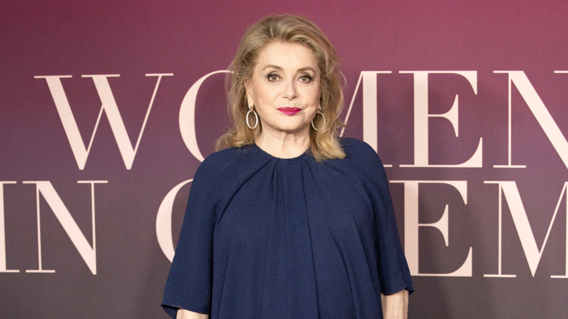 Catherine Deneuve en robe drapée bleu marine et maquillage sixties : l’actrice incarne le chic à la française à Antibes