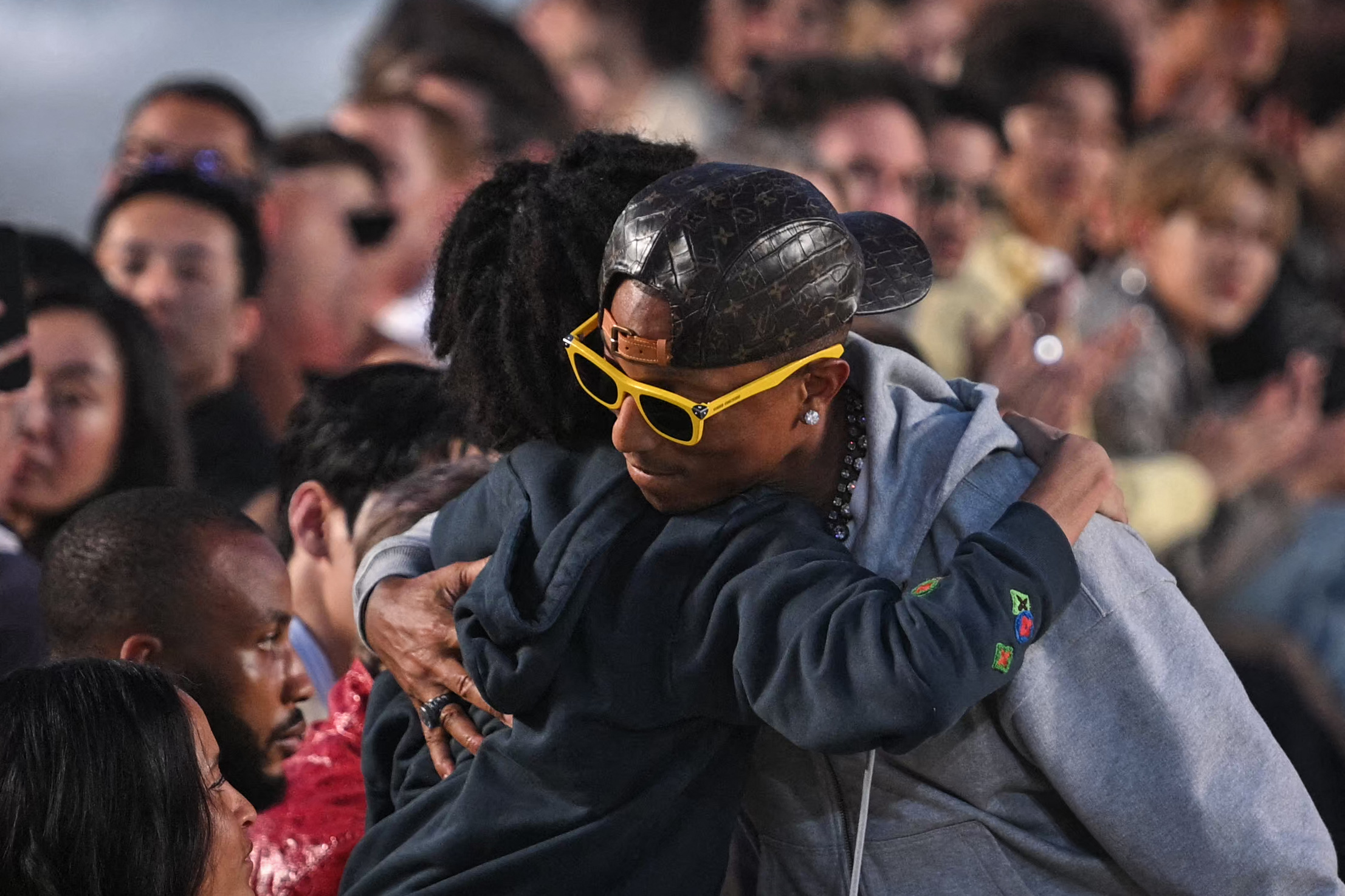 Cet instant de complicité entre Pharrell Williams et sa famille, au grand complet au premier rang du défilé Louis Vuitton