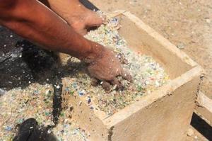 Les bouteilles, matiÃ¨re premiÃ¨re dans la fabrication du bÃ©ton, sont broyÃ©es en petites billes et transportÃ©es sur le chantier dans dâ€™Ã©normes sacs.