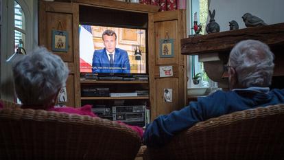 Des téléspectateurs regardent le président de la République, Emmanuel Macron, prononcer un discours à la télévision pour parler de la situation sur l’épidémie du coronavirus.