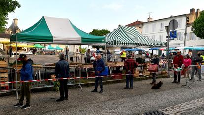 Des habitants de Cadillac, près de Bordeaux font la queue, attendant leur tour d’entrer sur le marché.