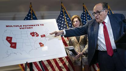 Jeudi, à Washington, lors d'une conférence de presse, l'avocat de Donald Trump, Rudy Giuliani, montre sur une carte les six États contestés par les équipes du président.