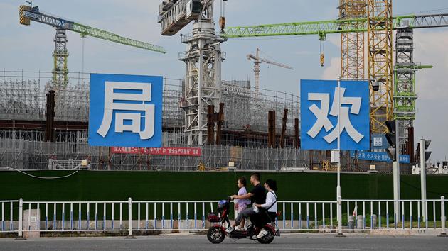 Une famille de Chinois observe le chantier du stade de Guangzhou, réalisé par le groupe Evergrande.