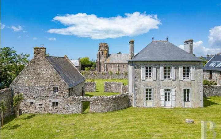 Le presbytère (à droite) s’accompagne d’une dépendance (à gauche). Au second plan, une ancienne église du 13e siècle.