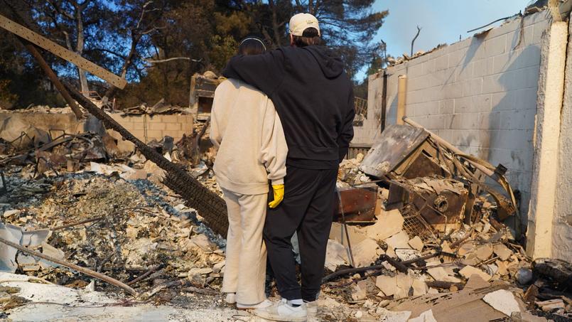 À Los Angeles, le quartier de Pacific Palisades laisse place à un paysage de désolation. Ici, un couple inspecte les débris de sa maison jonchant le sol.