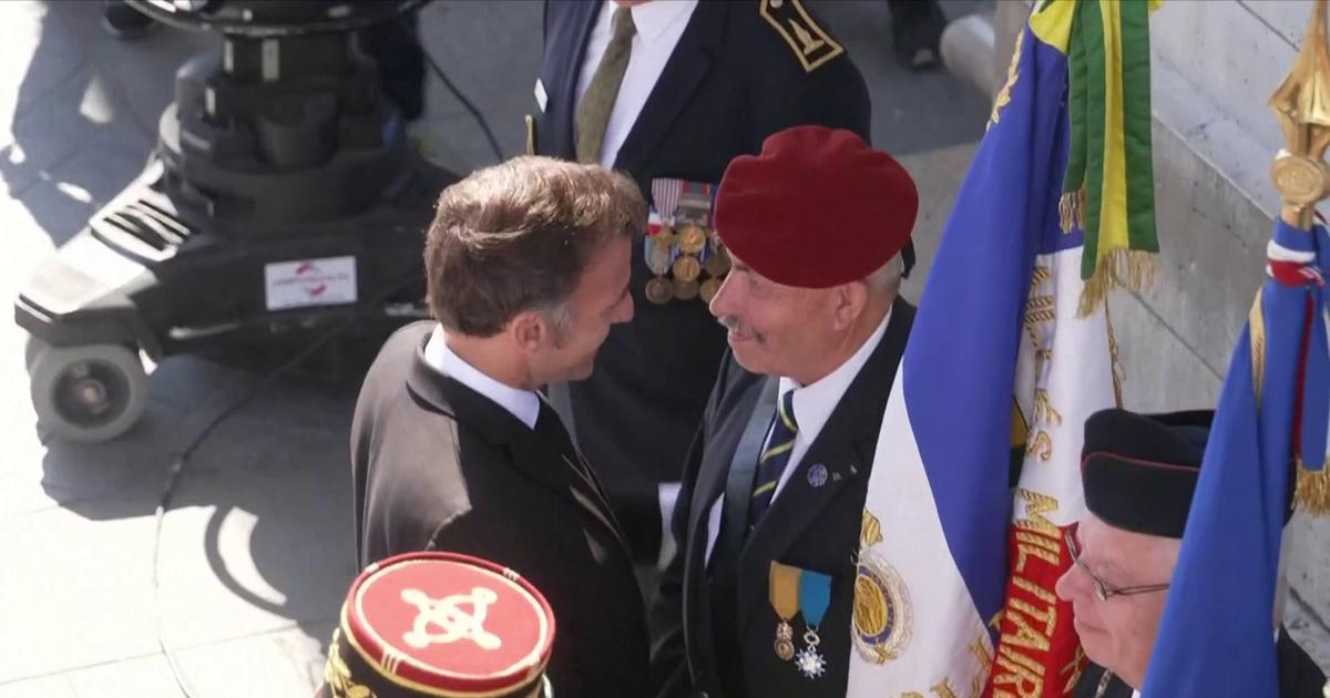 Emmanuel Macron salue le comité de la flamme et les porte-drapeaux lors de la commémoration du 8 mai