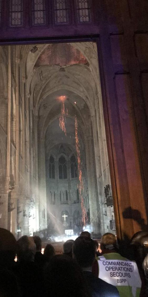 Le général Gallet vient d’annoncer la nouvelle tant espérée: «La structure de Notre-Dame est sauvée et préservée dans sa globalité ». Emmanuel Macron encore présent veut rentrer dans la Cathédrale. Au fond on aperçoit la croix qui brille.