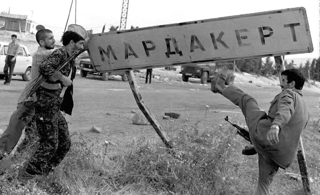 Un groupe de soldats azerbaïdjanais détruit un panneau routier indiquant la ville arménienne de Mardakert dans le Haut-Karabakh, le 10 juillet 1992. © MAXIMOV / AFP