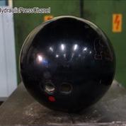 Une boule de bowling éclatée par une presse hydraulique