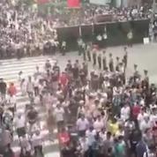 La police chinoise forme des boucliers humains pour protéger les milliers de passants qui traversent la route