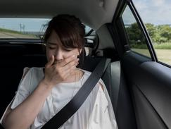 Une femme est malade pendant un trajet en voiture