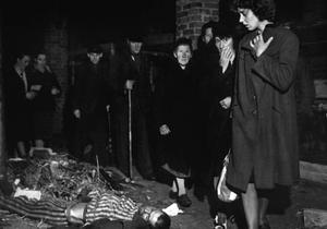 Des civils allemands défilent devant les corps de déportés, après la libération des camps.