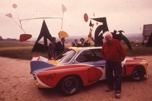 Alexander Calder prend la pose devant la BMW 3.0 CSL qu'il a peinte.