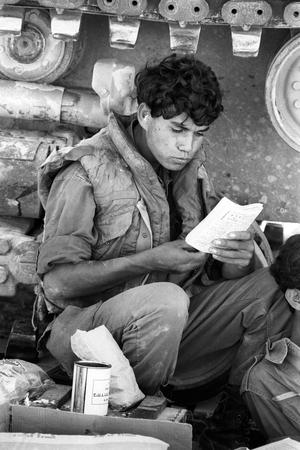 Un jeune israélien lisant un cahier sur le front syrien (plateau du Golan) lors de la guerre du Kippour en octobre 1973.