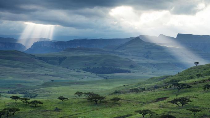 Fin de journée sur les Drakensberg. Les derniers rayons du soleil percent les nuages pour frôler les sommets de Champagne Castle et Monks Cowl.