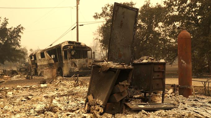  A bus and the rubble of a house burned down 