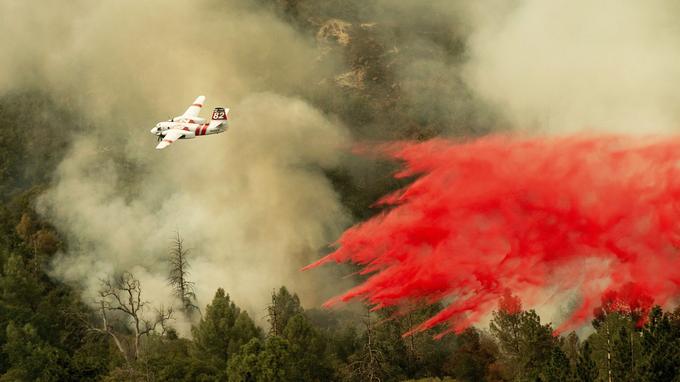  A tanker drops a self-timer as he fights to prevent Ferguson's fire from reaching Darrah Community homes in Mariposa Count, California on Wednesday July 25, 2018. 