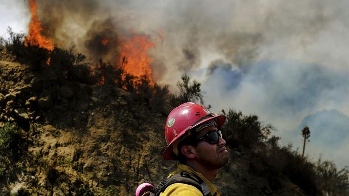  A firefighter watches the "Cranston" fire grow to over 1,200 acres in the San Bernardino National Forest above Hemet, California on Wednesday, July 25, 2018. 