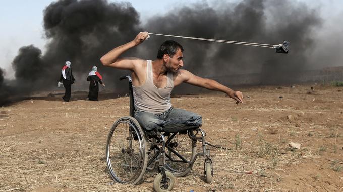 Saber al-Ashkar, un Palestinien de 29 ans, lance des pierres lors d'affrontements avec les forces israéliennes le long de la frontière de la bande de Gaza, à l'est de la ville, le 11 mai 2018. Les Palestiniens manifestaient contre le transfert à Jérusalem de l'ambassade américaine en Israël.