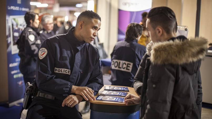Un jeune homme interroge un policier sur le stand de recrutement de la police nationale, au Salon de l'étudiant, Porte de Versailles, à Paris, en février 2016.