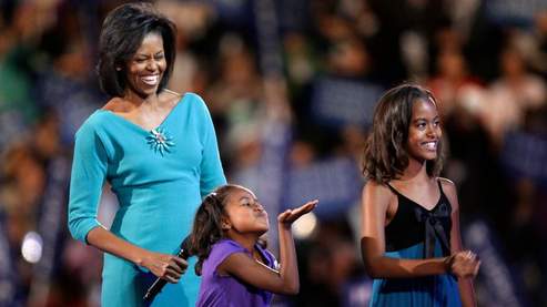 Michelle Obama et ses filles, l'aînée Malia et la cadette Sasha qui envoie des baisers à son père (AP Photo/Charlie Neibergall).
