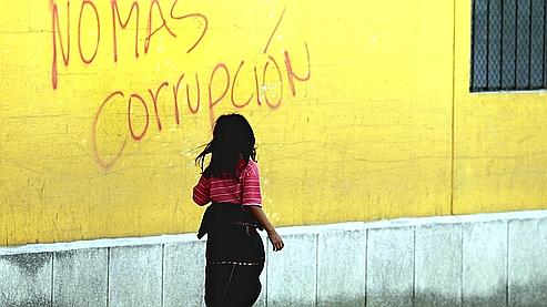 Sur cette photo prise en 2003 au Guatemala, une fillette passe devant un mur tagué «Stop à la corruption». Le pays est passé du 111e au 96e rang dans le classement de Transparency International.