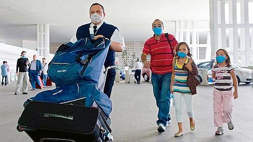 Une famille à l'aéroport de Mexico. Les étrangers sont nombreux à se hâter de quitter le pays, dans la crainte de nouvelles restrictions ou annulations de vols après l'alerte de l'OMS.