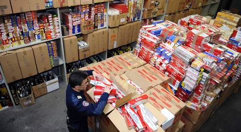 Un dounaier vérifie le contenu d'un carton de cigarettes de contrebande dans un hangar de stockage secret à la frontière entre la France et l'Andorre, le 10 mars 2009.