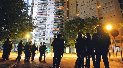 Des policiers en faction devant des immeubles du quartier de La Villeneuve, le 18 juillet à Grenoble, après les violences qui ont suivi la mort d'un braqueur présumé tué par la BAC.
