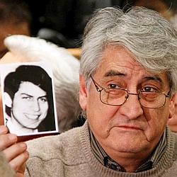 Bernard Alexandre Chanfreau brandit une photo de son frère Alphonse à l'ouverture du procès.