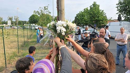 Des habitants du quartier ont accroché des fleurs sur un grillage situé sur le lieu de l'accident.