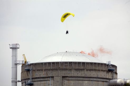 Un militant de Greenpeace lâche un fumigène sur le toit d'un réacteur.