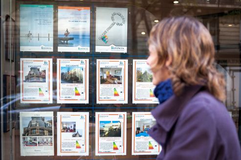 Femme regardant la vitrine d’une agence immobilière. Crédits photo: ARNAUD ROBIN / Le Figaro Magazine