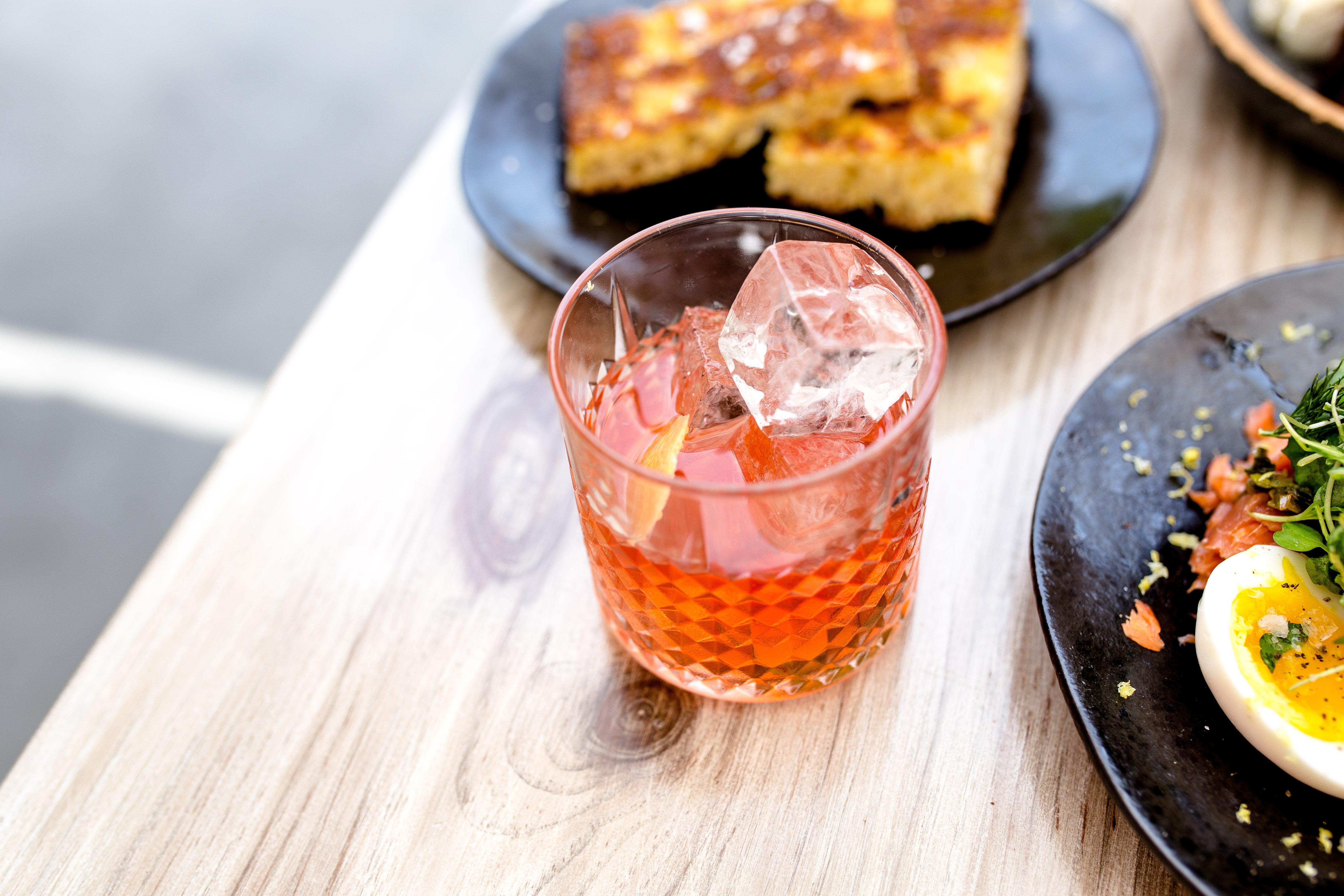 Verre De Cocktail Aperol Spritz Glacé Servi Dans Un Verre à Vin Avec Ananas  Et Grenat, Placé Sur Une Table Au Restaurant